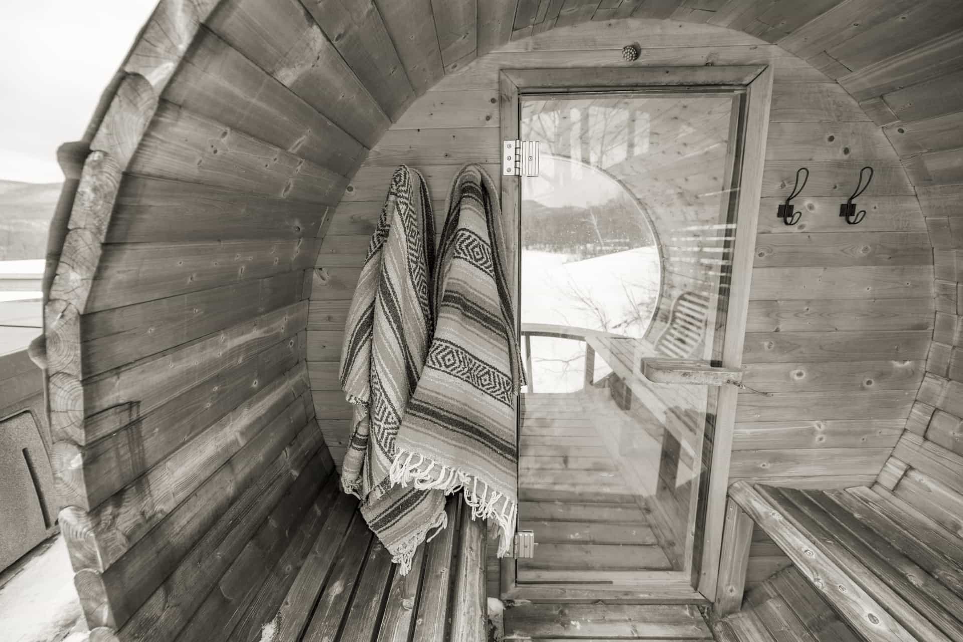 Wooden barrel sauna in a snow-covered garden