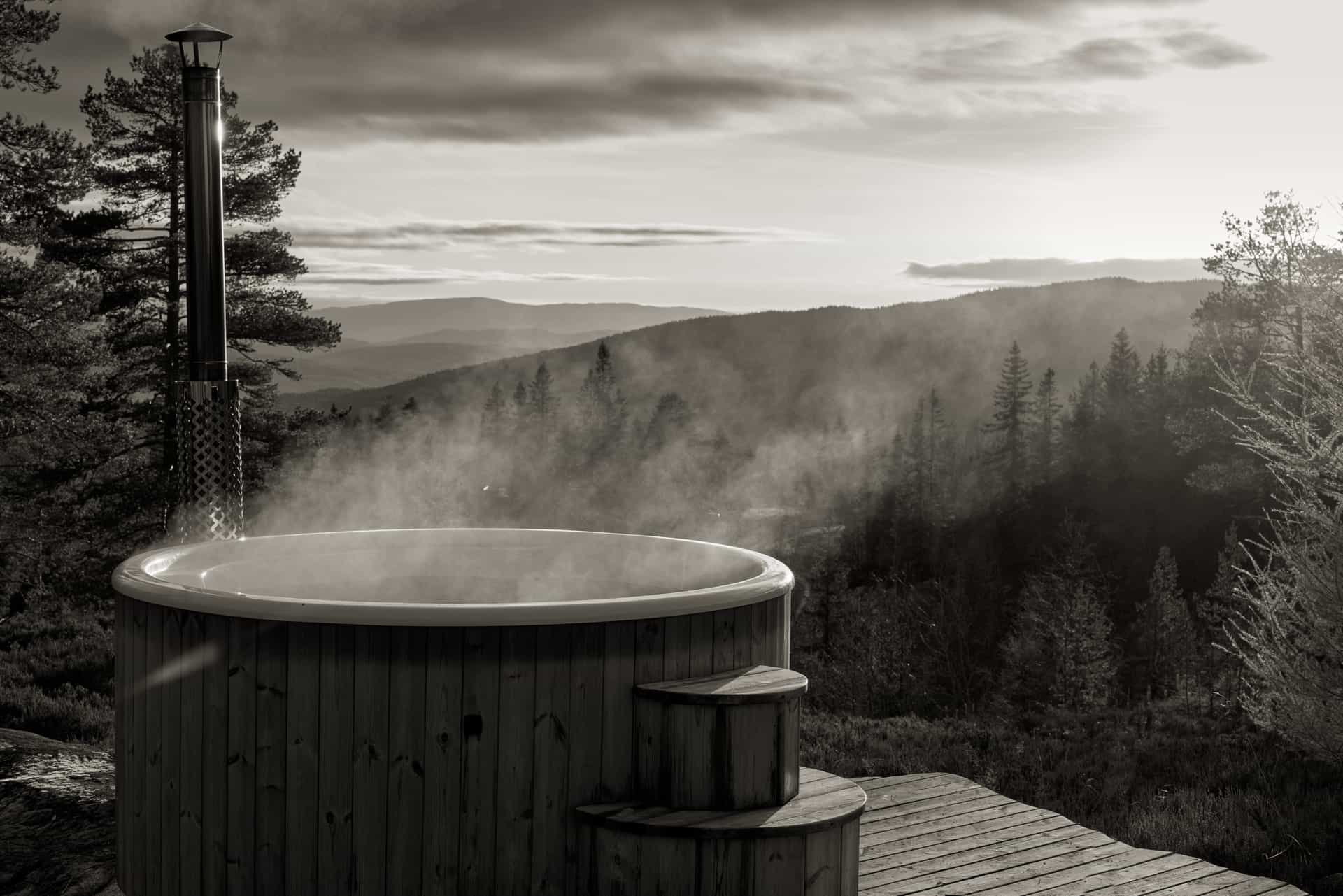 Outdoor hot tub steaming on a deck in the evening