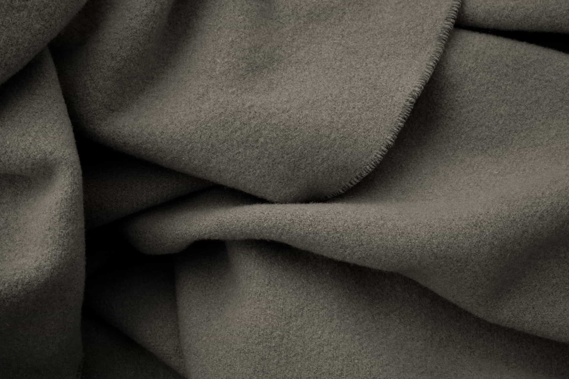 Infrared sauna blanket folded on a bed